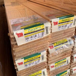 Piles de paquets de parquet Parqueco en pin des Landes, 23 mm d'épaisseur, lames de 2000x140 mm, 1,40 m² par paquet.