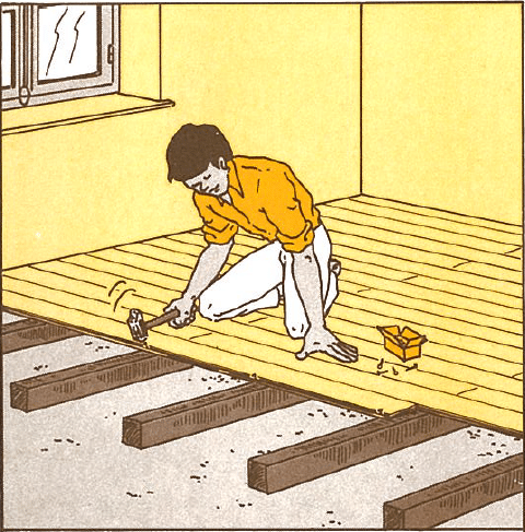 Pose de parquet bois : installer son sol facilement Homme agenouillé posant un parquet en bois clair avec un marteau sur des lattes. Une boîte de clous est à côté de lui.